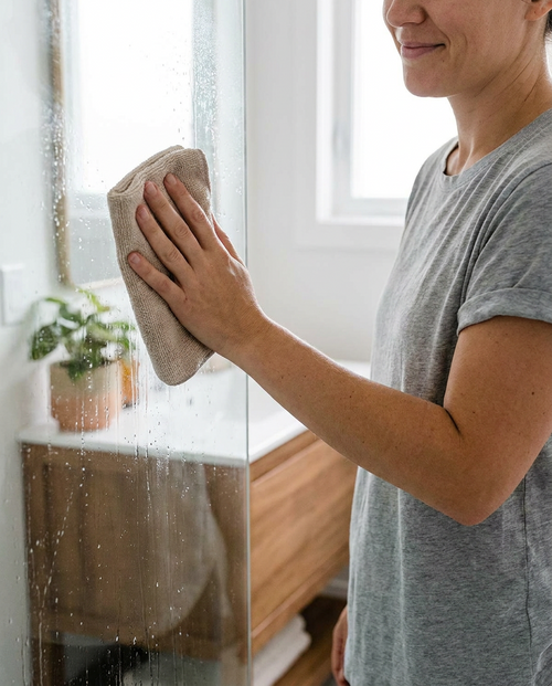 Doek in gebruik, douchedeur schoonmaken